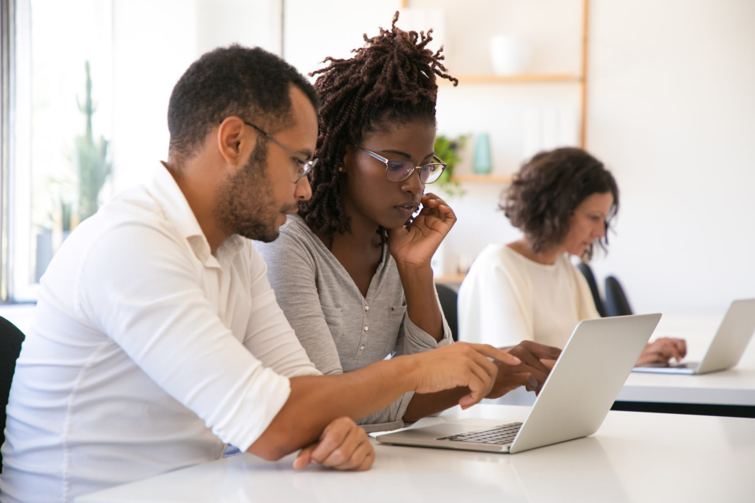 Formation logiciel Contact : un formateur accompagne une stagiaire sur son poste de travail